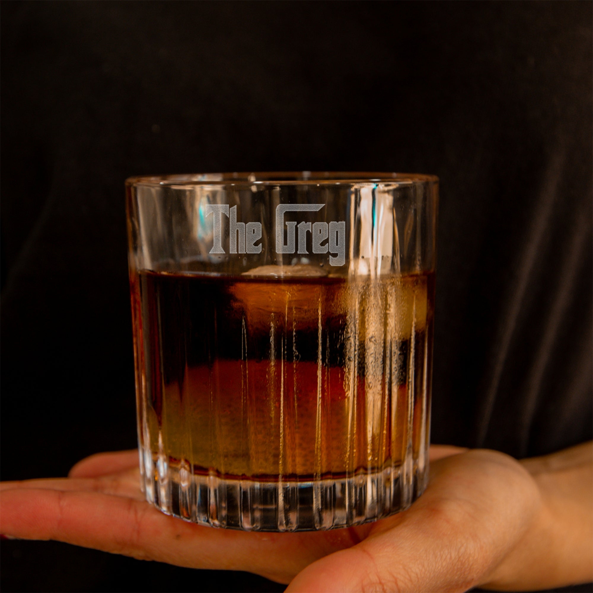 Glass of whiskey held by a hand with 'The Grey' by Yoonek Gifts