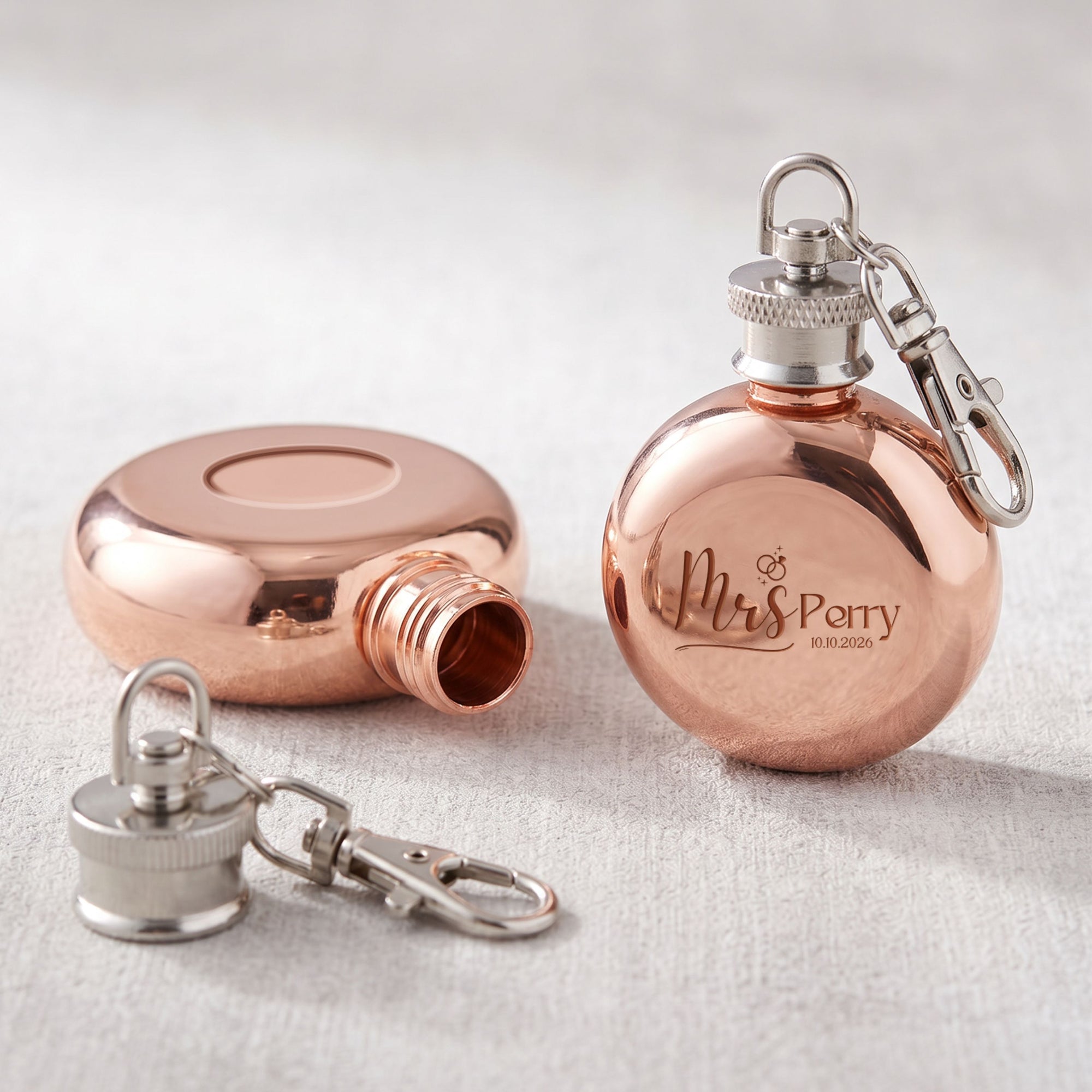 Close-up of laser engraved name on personalised mini round hip flask keyring