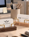 Engraved wooden business card holders with custom logos on a desk