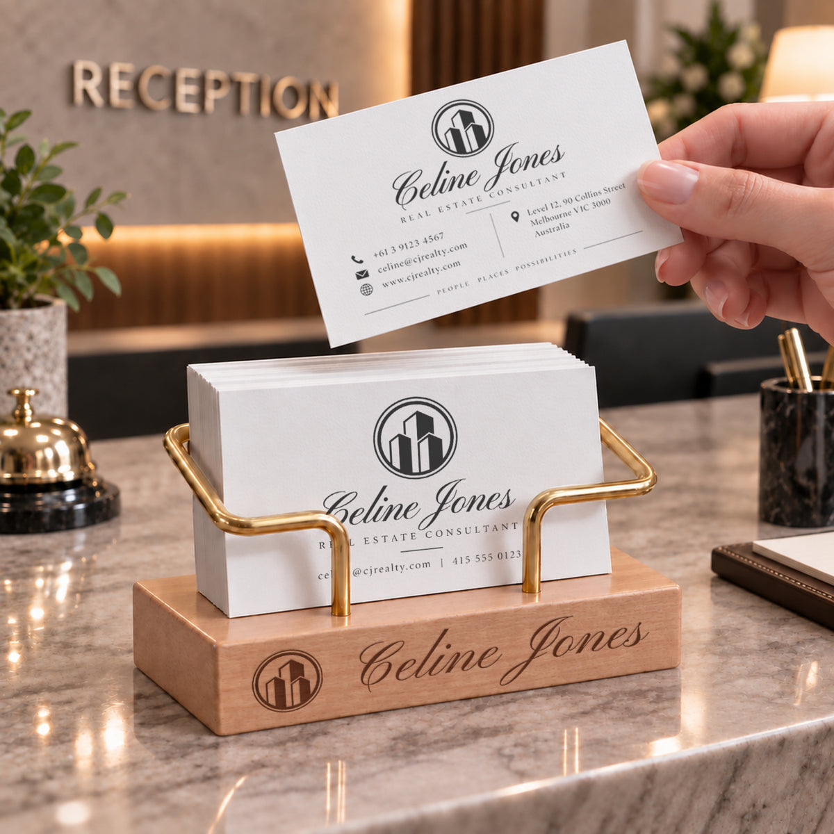 Personalised beech business card holder with brass stand at a reception counter