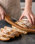 Wooden bread knife slicing sourdough loaf